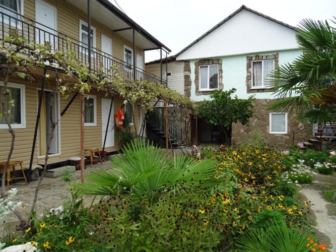 a house with a garden in front of it at Гостевой дом ЭДЕМ in Gagra