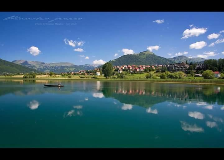 a lake with a boat in the middle of it at Rooms Lida & Friendly home in Plav