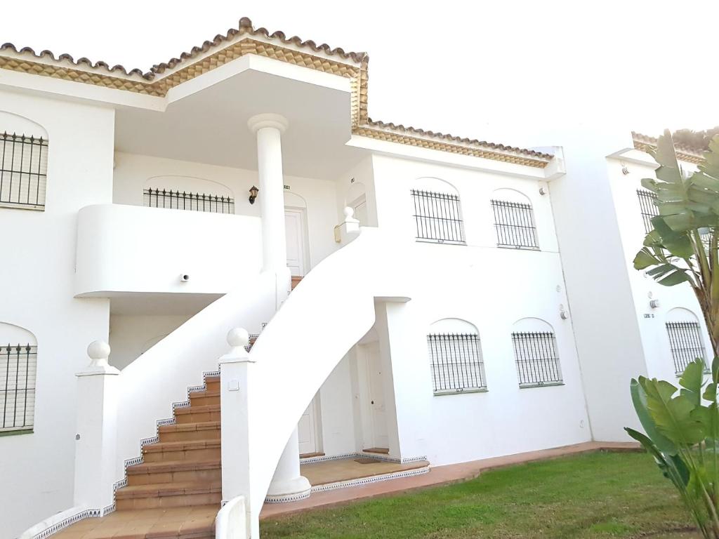 a white house with a spiral staircase at Apartamento Pinar del Atlántico-La Barrosa in Chiclana de la Frontera