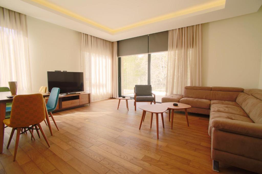 un soggiorno con divano e tavolo di Luxury Home in Tivat Centre w/ Parking - 2Br Near Porto Montenegro a Tivat