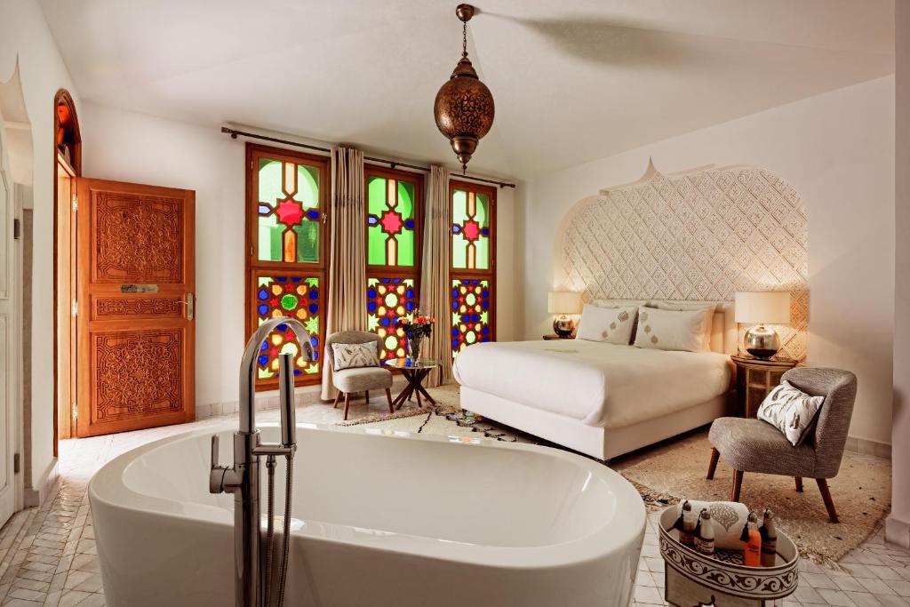 a bathroom with a tub and a bedroom with a bed at Emma's Riad in Marrakesh
