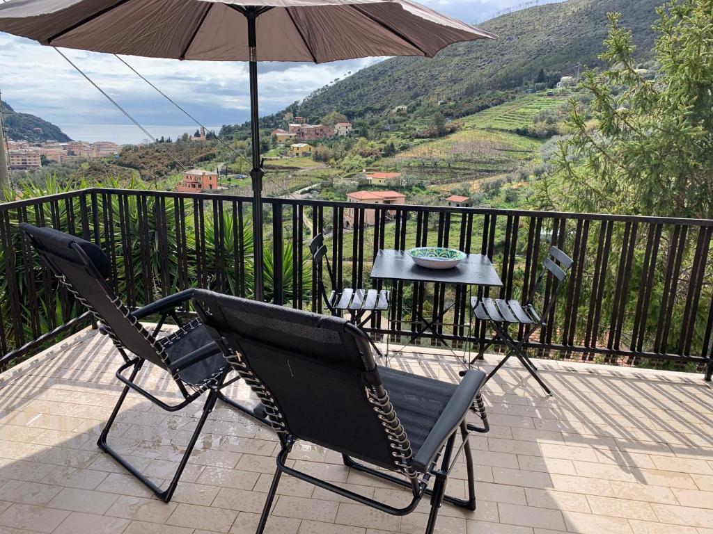 ein Paar Stühle und ein Regenschirm auf dem Balkon in der Unterkunft Riviera in Levanto