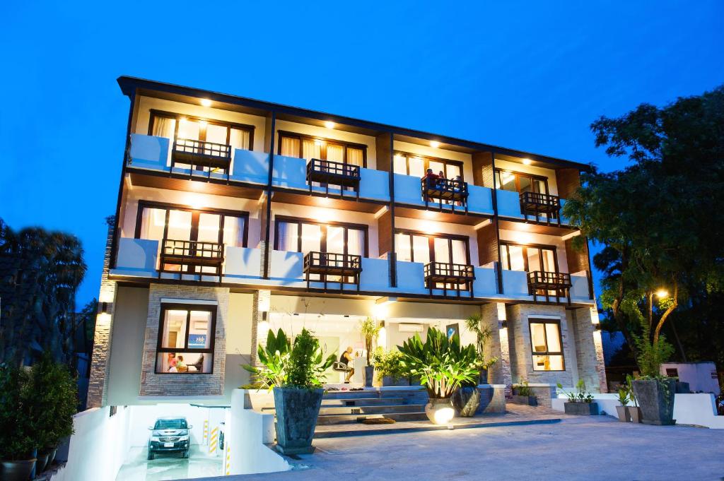 a large building with balconies on it at night at Montien House - SHA Plus in Chaweng