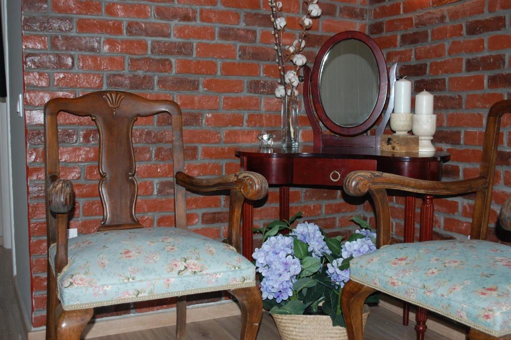 two chairs and a mirror on a brick wall at Cosy Home Boutique Apartment in Perea