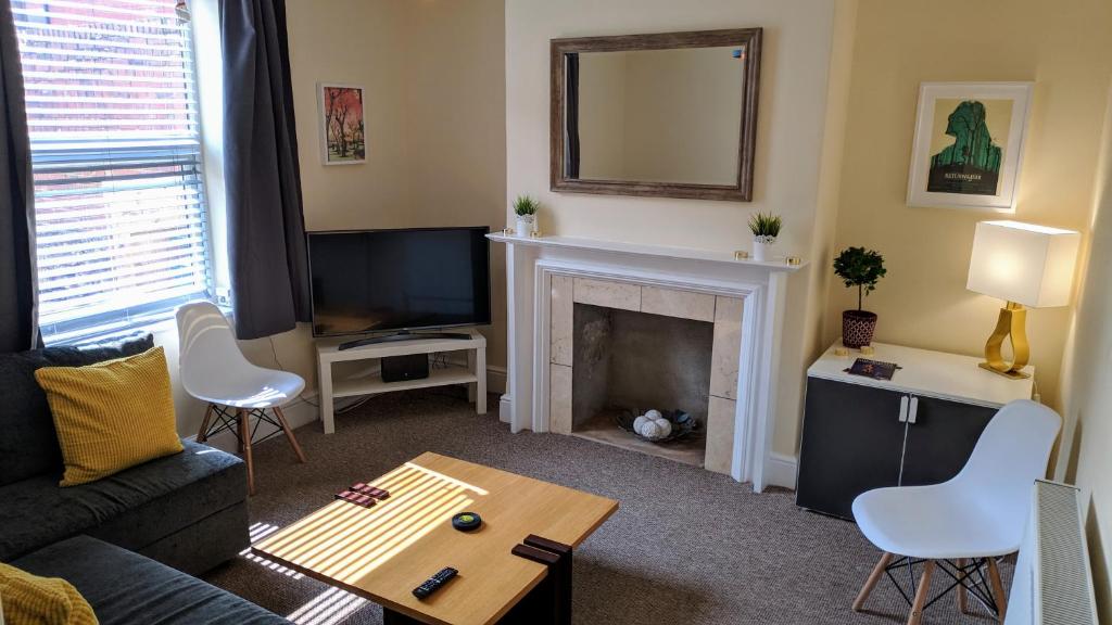 a living room with a couch and a fireplace at Pavilion House in Exeter