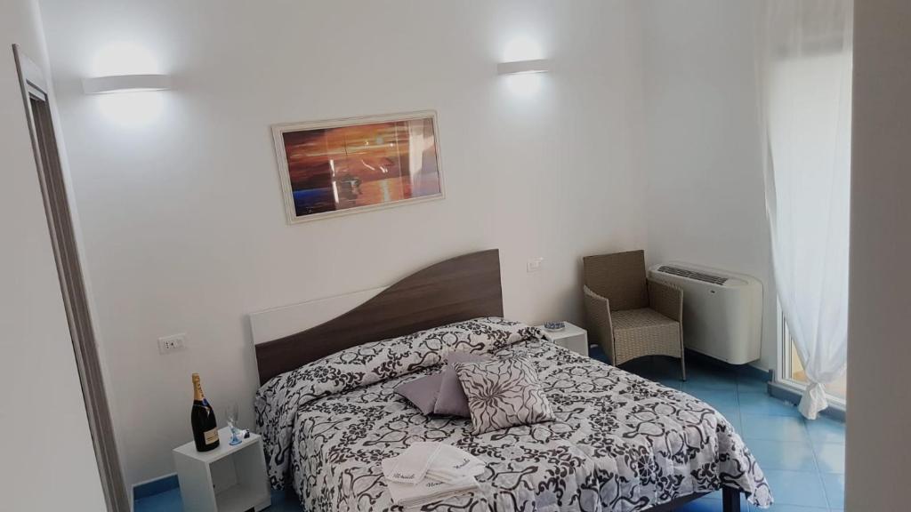 a small bedroom with a bed and a chair at Nereide in Tropea