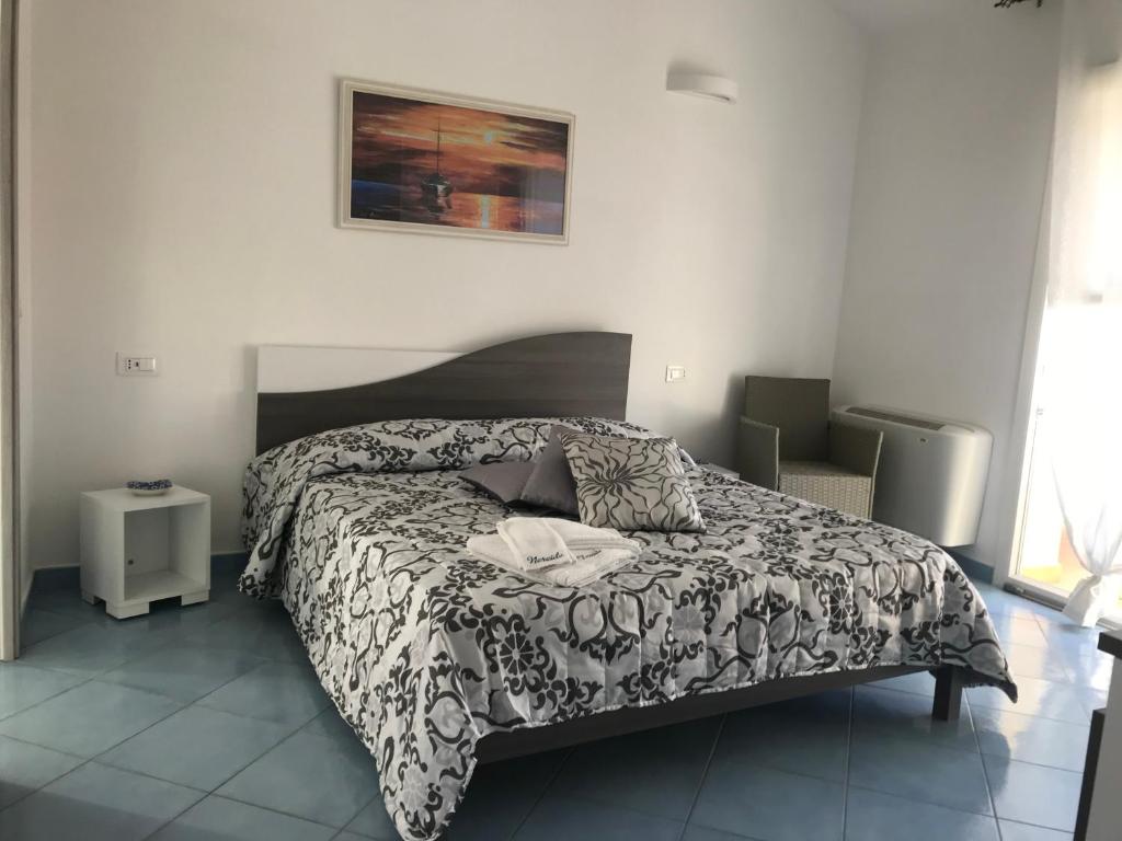 a bedroom with a bed with a black and white comforter at Nereide in Tropea