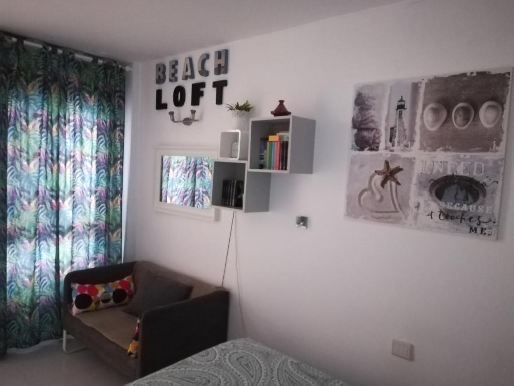 1 dormitorio con 1 cama y 1 silla en una habitación en Apartamento Beach Loft Las Canteras, en Las Palmas de Gran Canaria