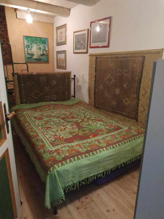 una camera da letto con un letto con una coperta verde sopra di Zentrales kleines Appartment a Klagenfurt