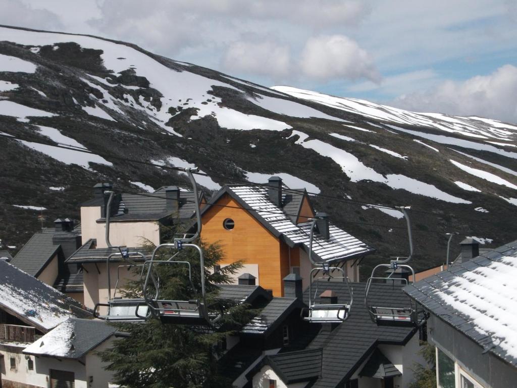 a group of houses in front of a snow covered mountain at Apartamentos Sierra Nevada Welcome in Sierra Nevada