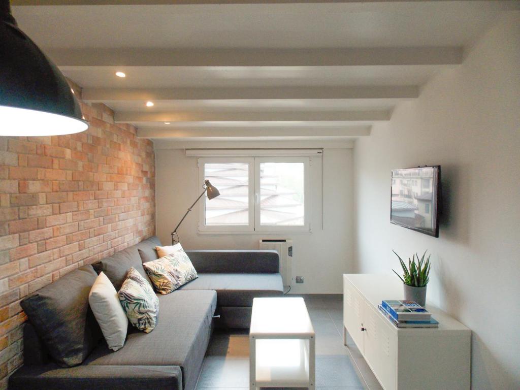 a living room with a couch and a brick wall at Apartamento Sanxenxo Centro in Sanxenxo