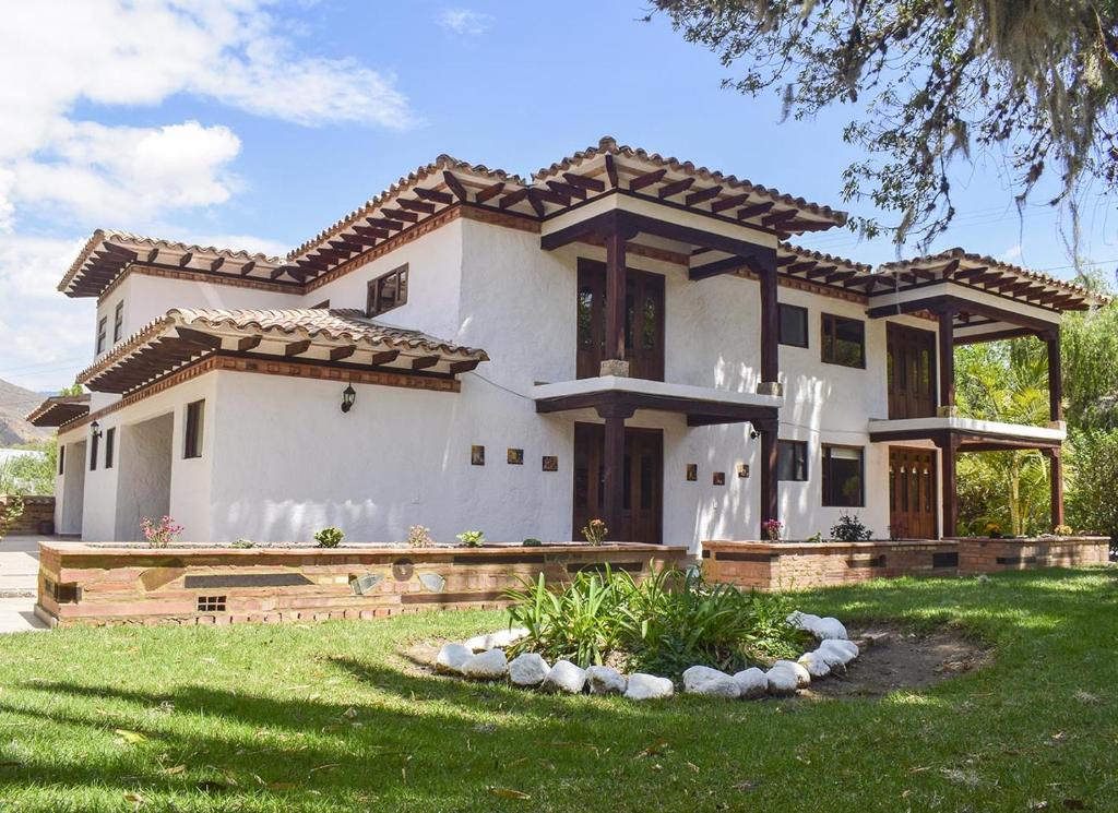 a large white house with a roof at Hotel Hacienda Santa Cecilia in Sáchica