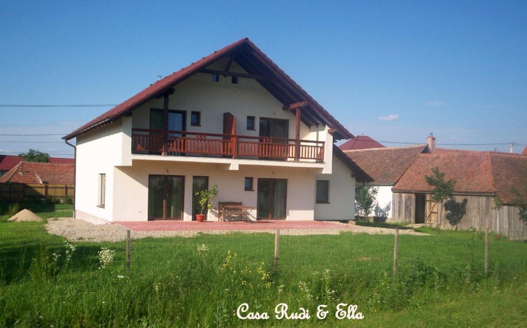 een wit huis met een balkon en een tuin bij Casa Rudi & Ella in Sălişte