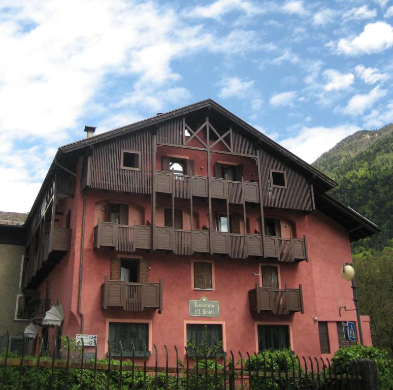a red building with balconies on the side of it at Albergo Locanda Mezzosoldo in Mortaso