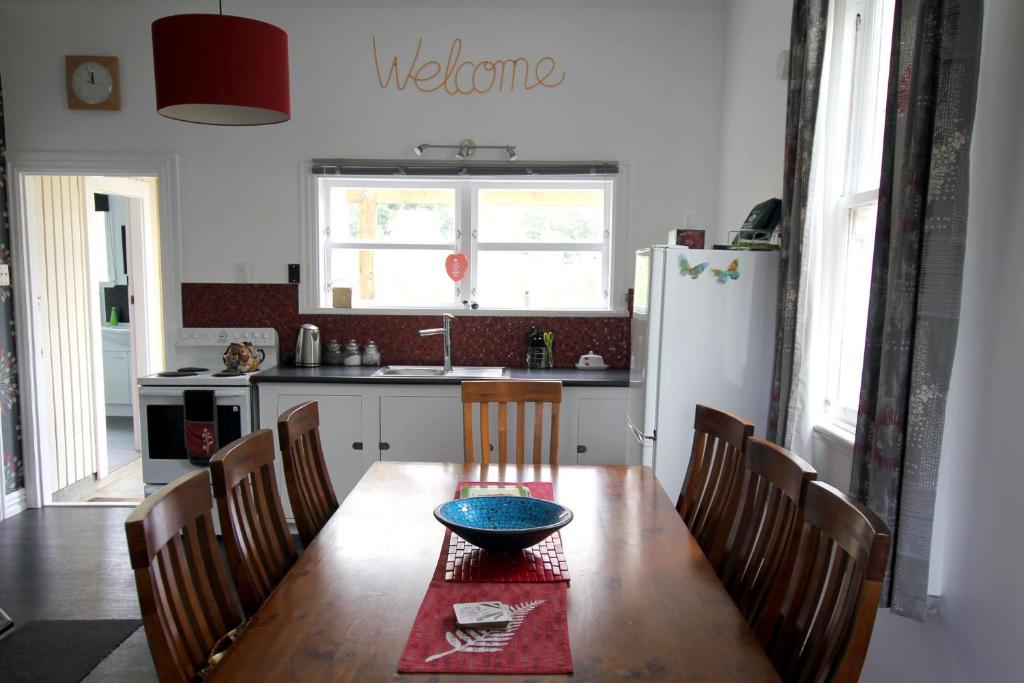 uma cozinha com uma mesa de madeira e um frigorífico em Whanga Bridge House em Whangamomona