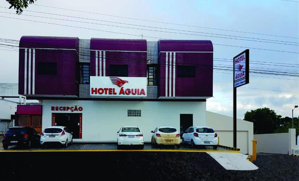 a hotel room with cars parked in front of it at Hotel Águia in Teixeira de Freitas