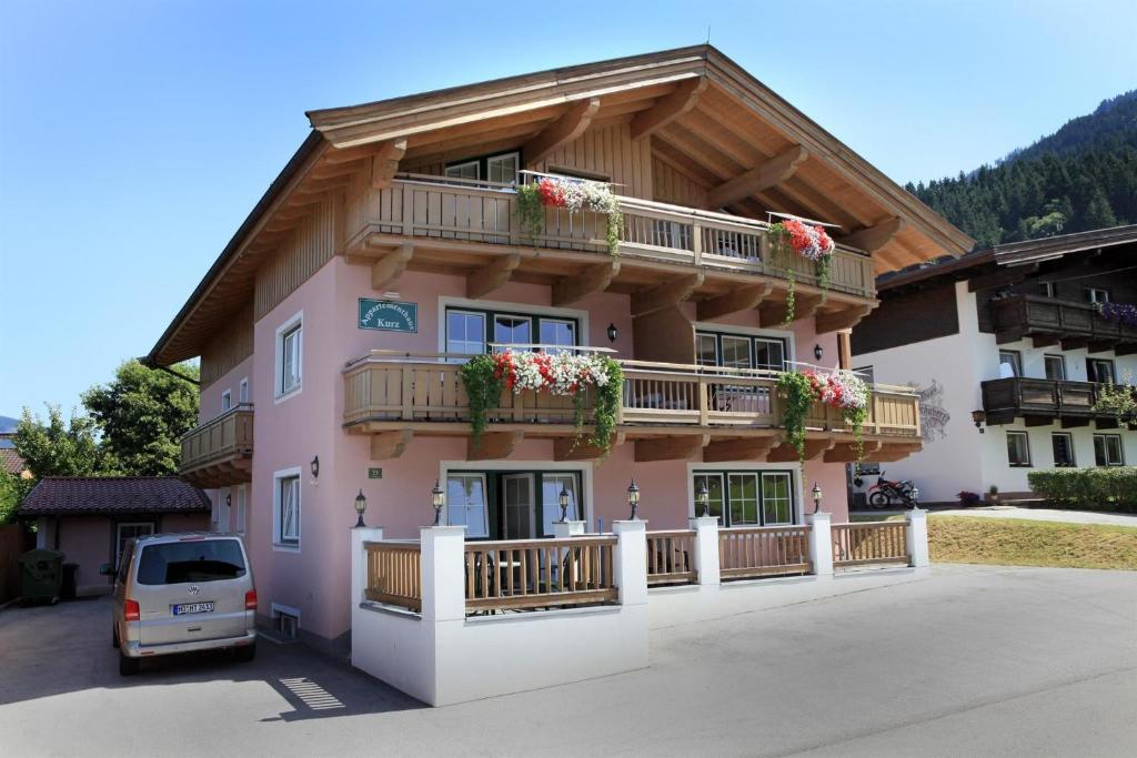 un edificio rosa con macetas en los balcones en Penthouse Kurz, en Westendorf