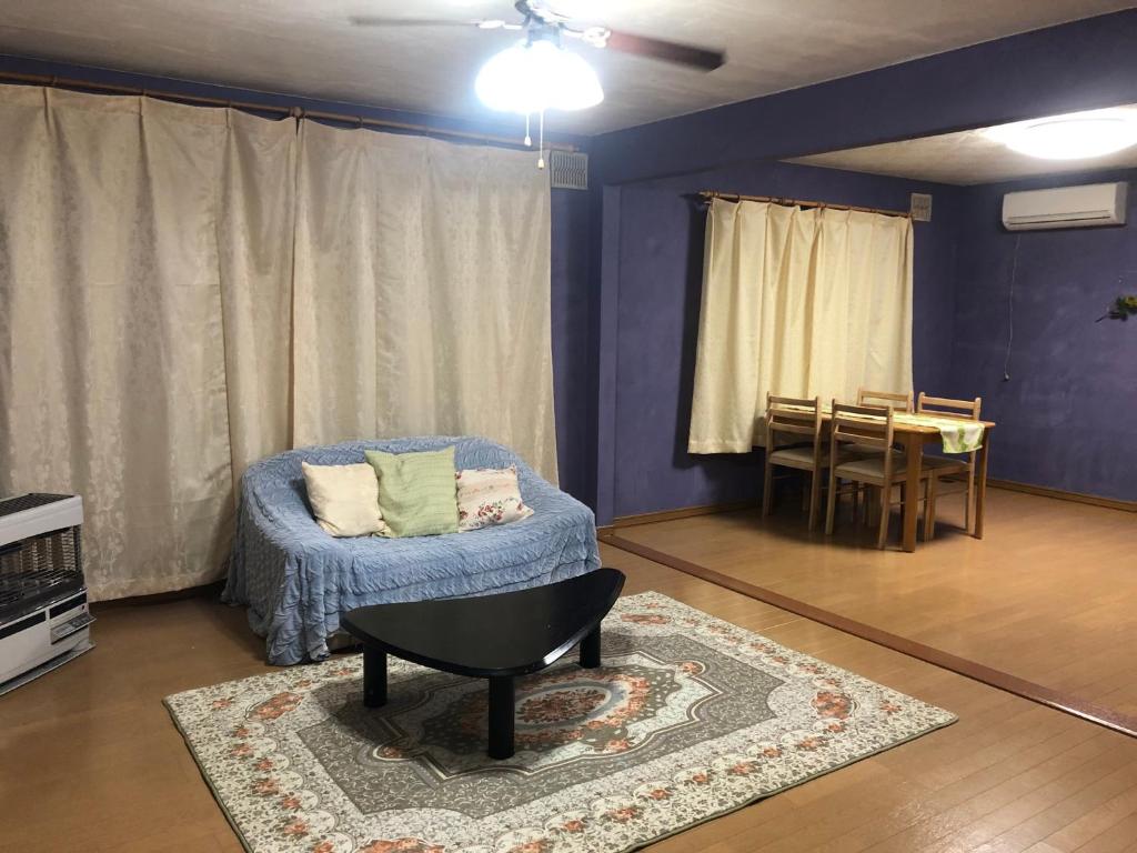 a living room with a blue couch and a table at STAY Sakura in Bibai