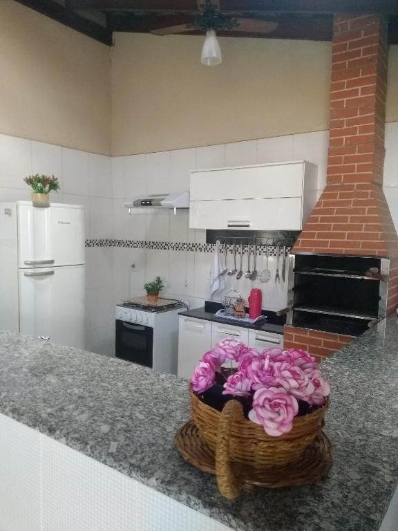 a kitchen with a basket of flowers on a counter at Recanto ferreira in Olímpia