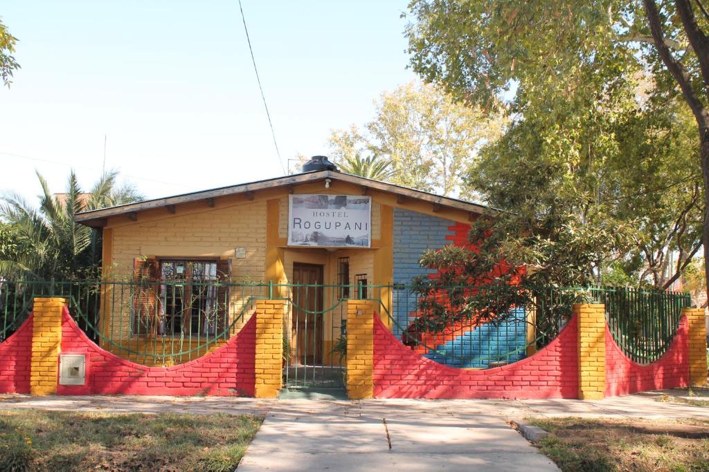 un edificio con una valla colorida delante de él en Hostel Rogupani en San Rafael