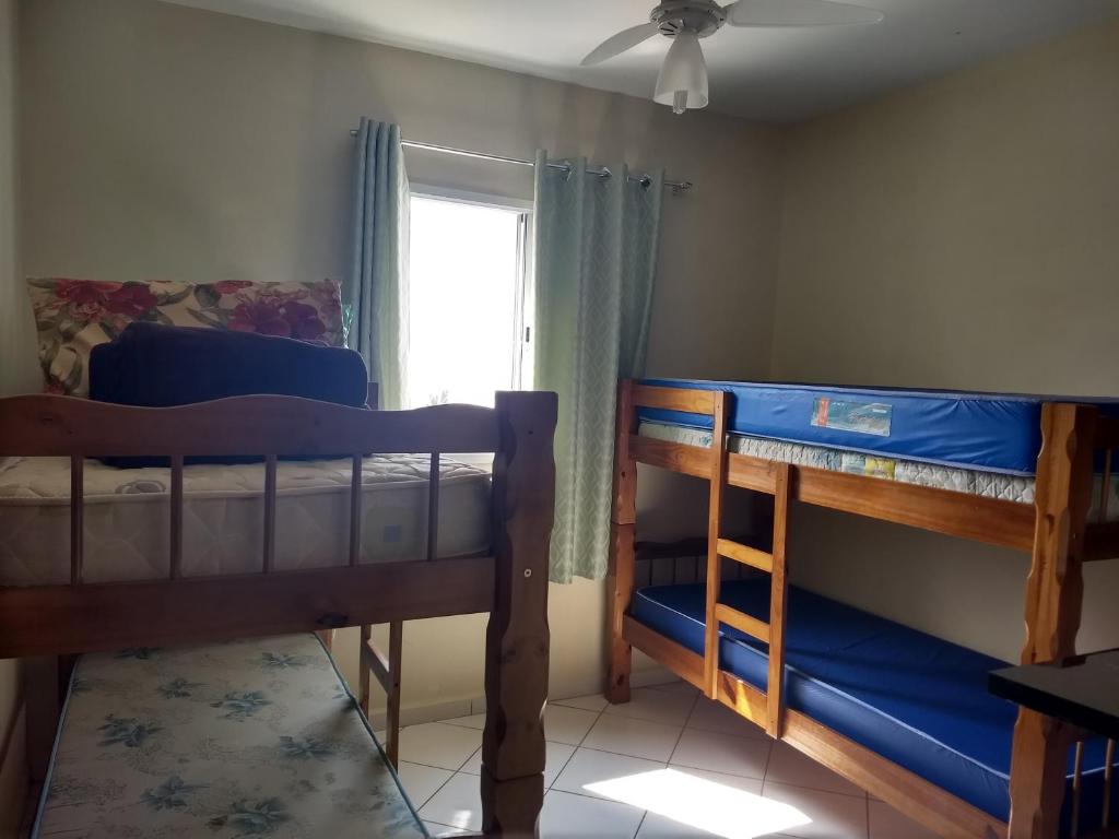 two bunk beds in a room with a window at Apto Verde Água in Mongaguá
