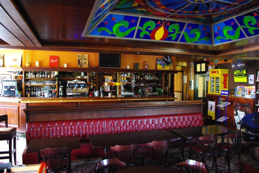 Le NayracにあるL'Auberge Fleurieの赤いベンチとカウンター付きのレストランのバー