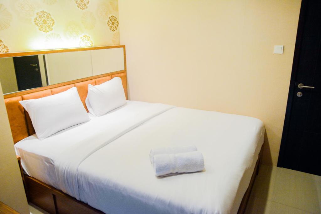 a bedroom with a white bed with a towel on it at Spacious 2BR GP Plaza Apartment By Travelio in Jakarta