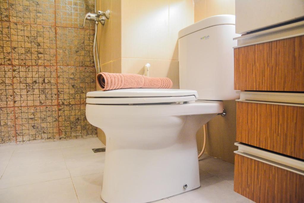 a bathroom with a toilet with a towel on it at Spacious 2BR GP Plaza Apartment By Travelio in Jakarta