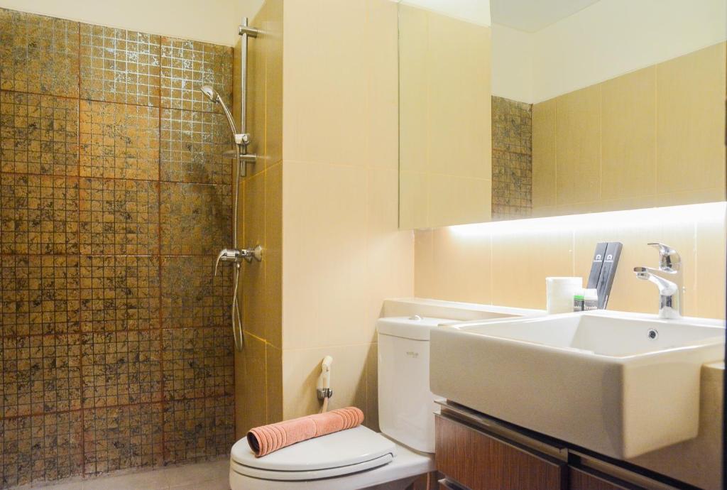 a bathroom with a sink and a toilet and a shower at Spacious 2BR GP Plaza Apartment By Travelio in Jakarta