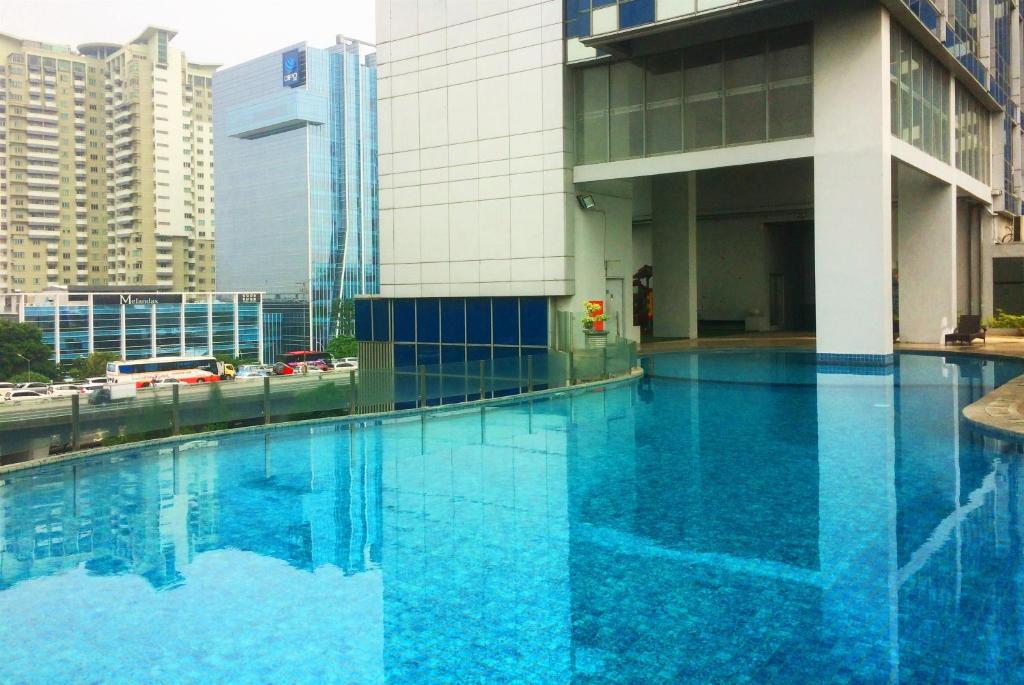 a large blue pool in front of a building at Spacious 2BR GP Plaza Apartment By Travelio in Jakarta