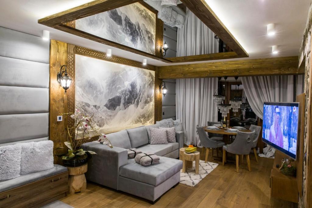 een woonkamer met een bank en een tafel bij Zakopane FIVE STARS in Zakopane
