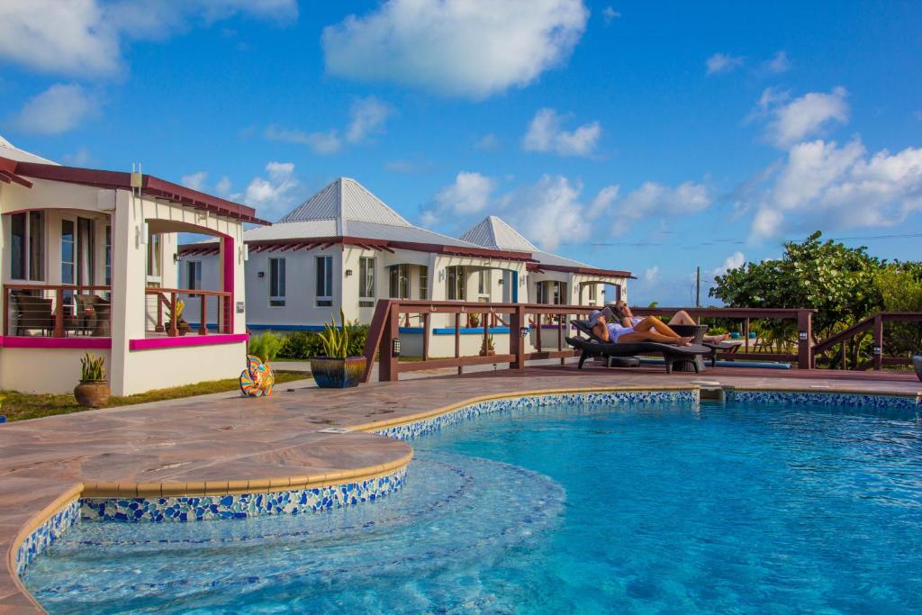 a villa with a swimming pool in front of a house at Four Diamonds Park Villas in The Settlement