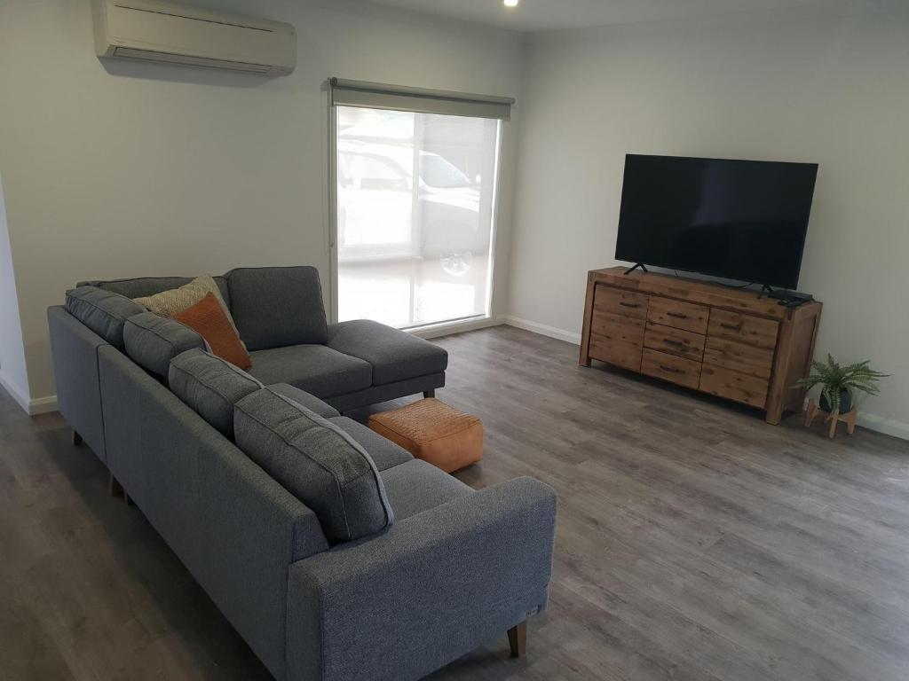 a living room with a couch and a flat screen tv at 123 Wilson - Arapiles in Horsham