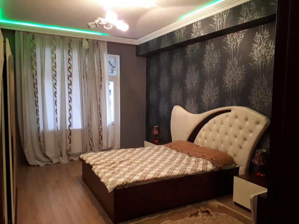 sypialnia z łóżkiem i ścianą z roślinami w obiekcie SEASIDE BOULEVARD 2 Bedrooms w mieście Baku