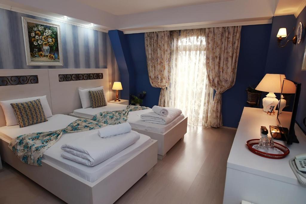 two beds in a room with blue walls at Hotel-Pensiunea Zefir in Timişoara