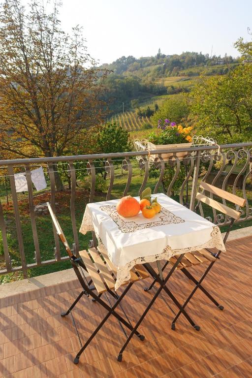 Ein Tisch und Stühle mit Orangen auf einem Balkon in der Unterkunft CasaRoman in San Floriano del Cóllio
