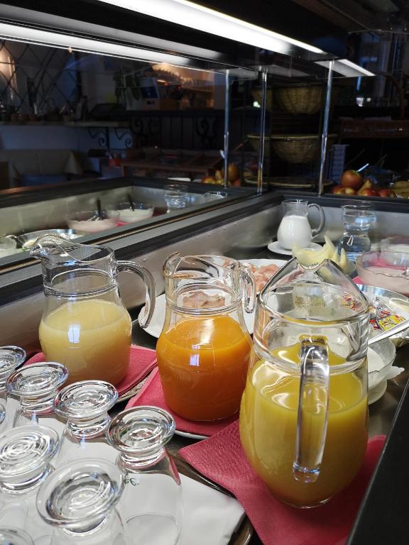 a bunch of glasses of orange juice on a table at Hotel Arcadia in Ascona