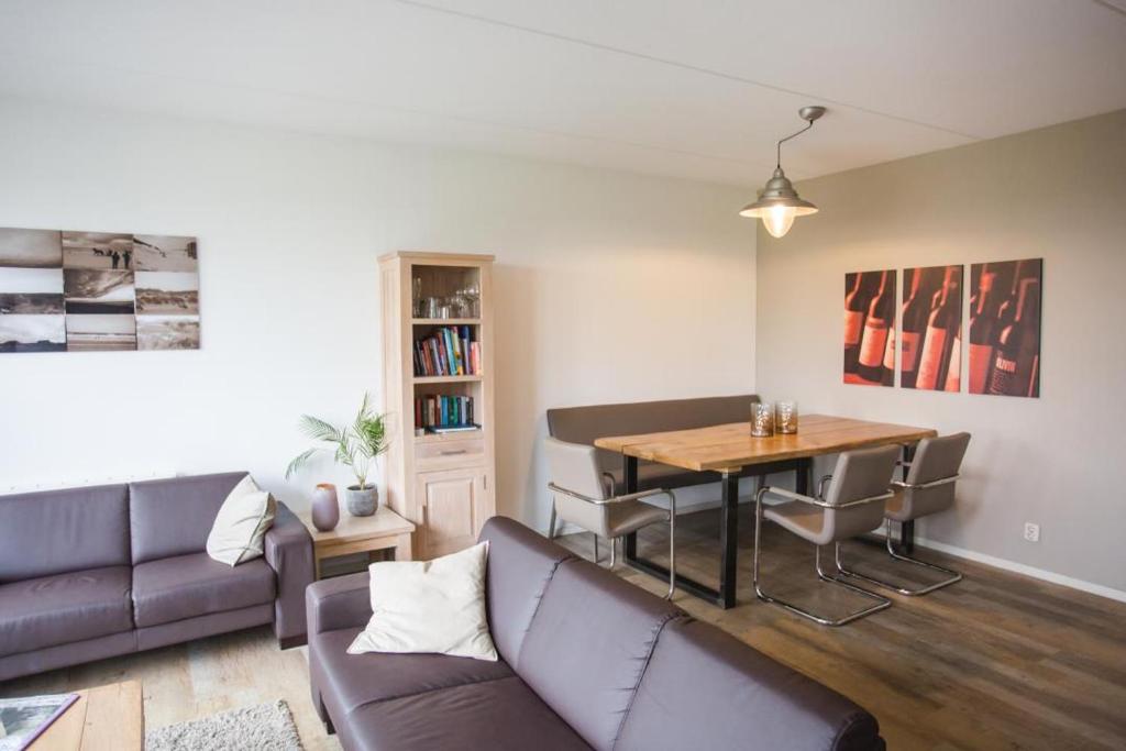 een woonkamer met een bank en een tafel bij Weidevilla 16 in Hollum