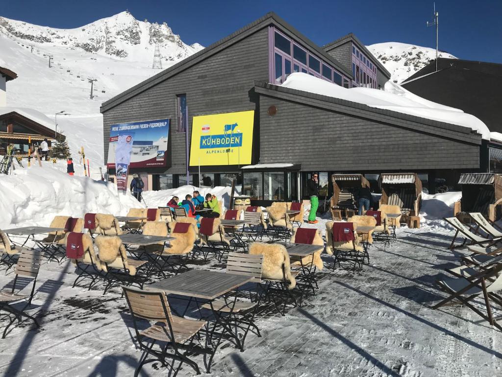 eine Gruppe von Stühlen und Tischen vor einem Gebäude in der Unterkunft Alpenlodge Kühboden in Fiesch