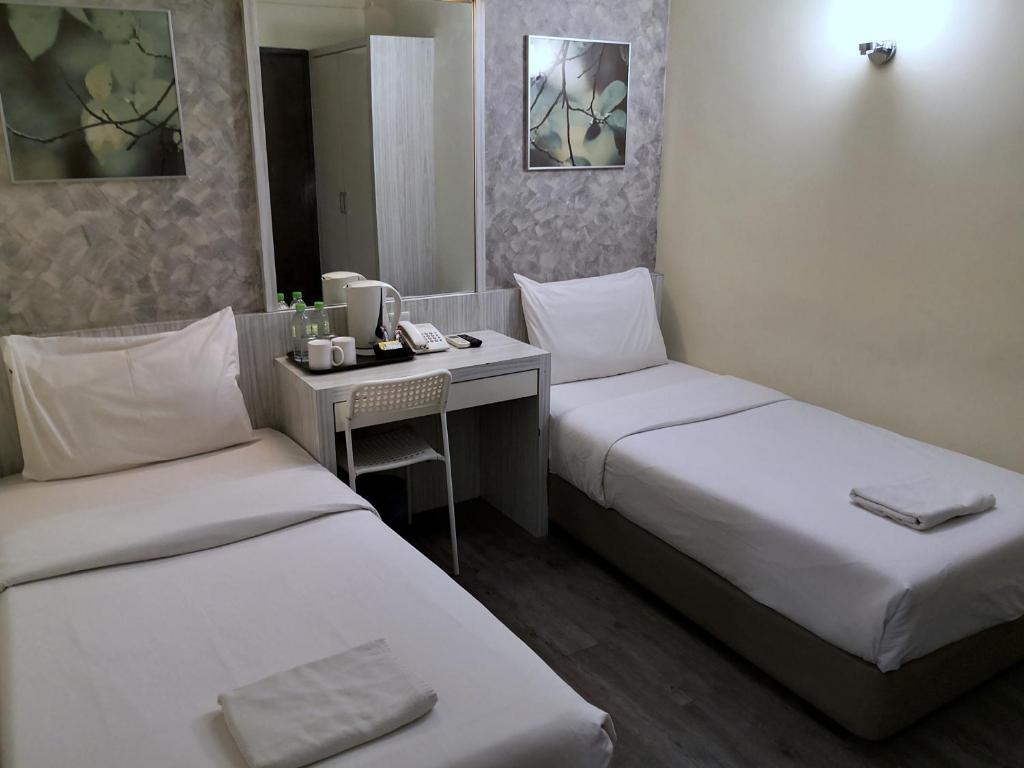 Another view of a compact twin room with a central hospitality desk.