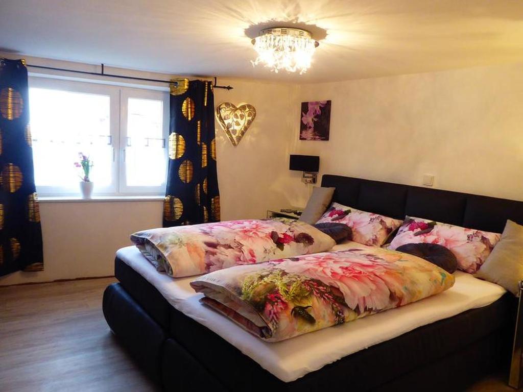 a bedroom with a bed with floral pillows on it at Ferienwohnung Kleiner Kalle in Melsungen