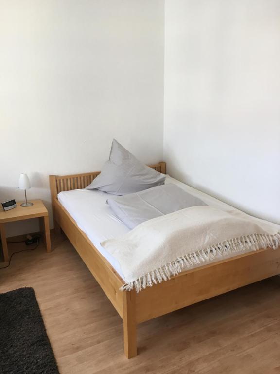 a bed in a room with a white wall at Ferienwohnung Schleswig in Schleswig