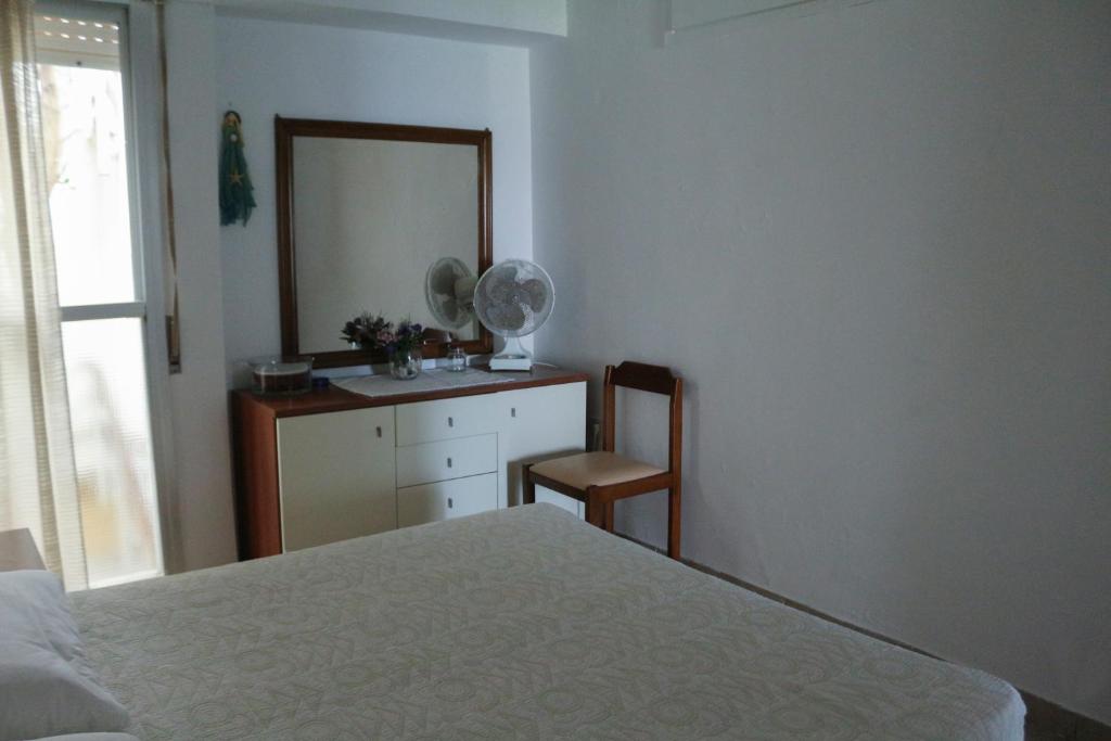 a bedroom with a bed and a mirror and a dresser at Holiday Home by the Sea in Nea Potidaea