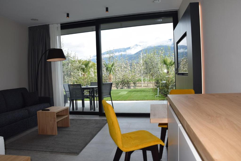 uma cozinha e sala de estar com mesa e cadeiras em Garden-Suite Faselehof em Marlengo