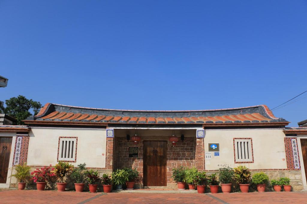 a building with plants in front of it at Longmen Inn Bed and Breakfast in Jinning