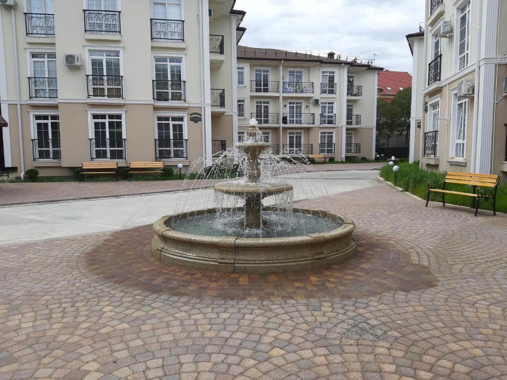 a fountain in the middle of a courtyard with buildings at Apartments Tsaritsino in Adler