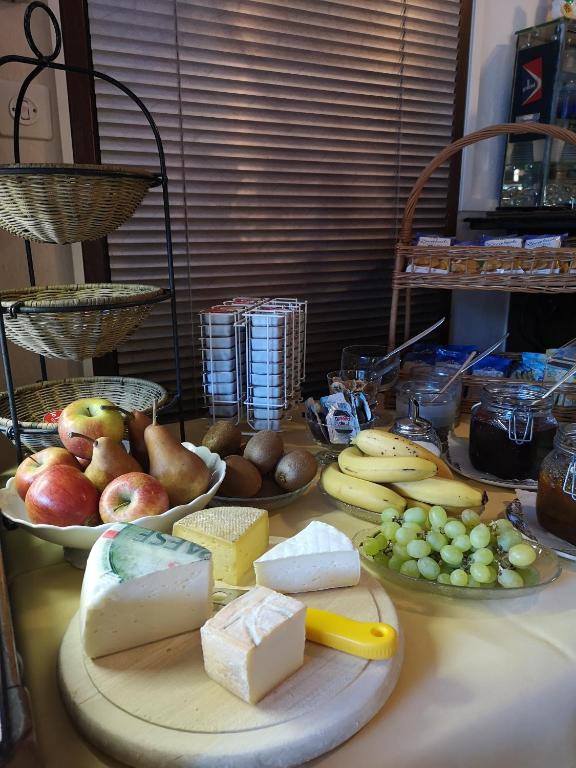 a table topped with plates of cheese and fruit at Hotel Arcadia in Ascona