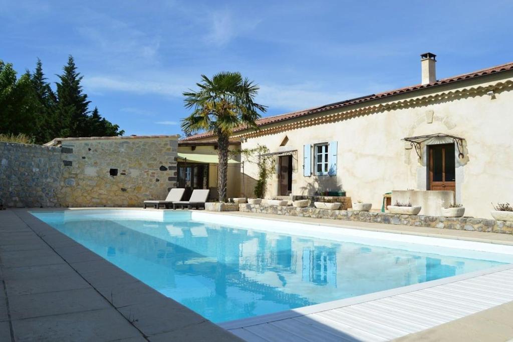 une villa avec une piscine en face d'une maison dans l'établissement Mas Ardechois proche Vallon pont d'arc, à Villeuneuve-de-Berg