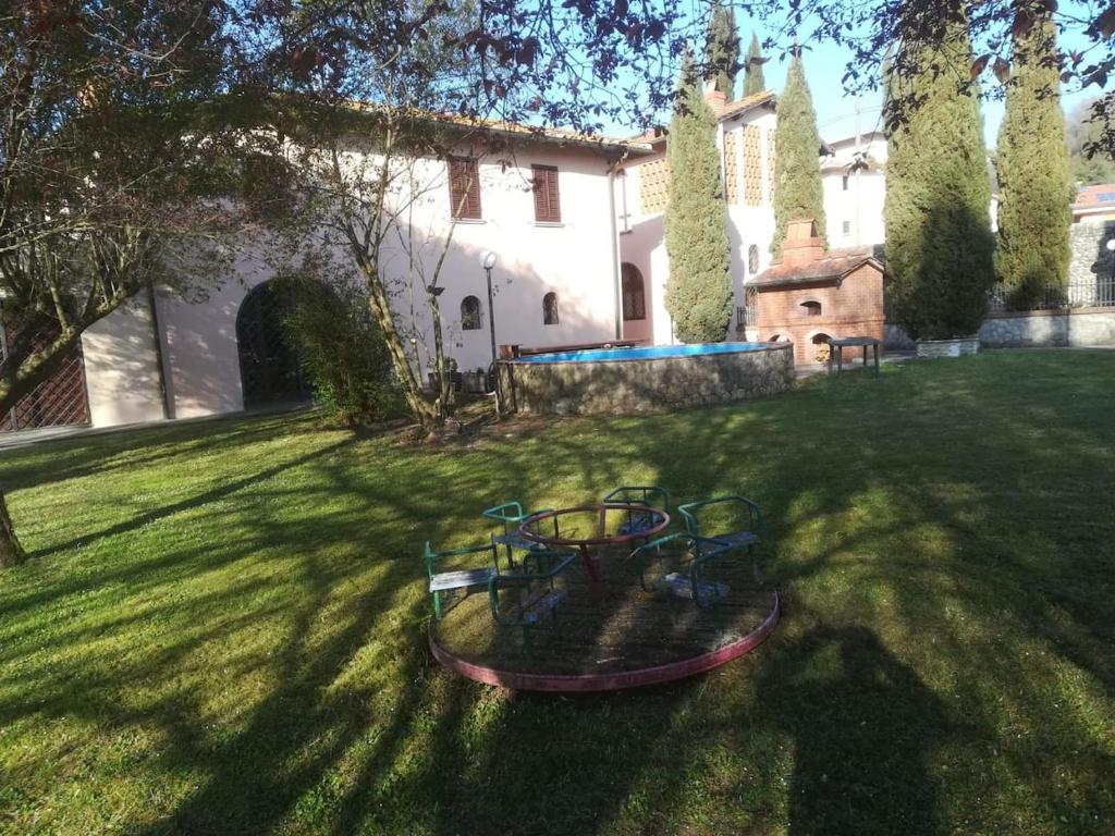 een tuin met een ronde speelplaats in het gras bij Villa Pancrazzi in Figline Valdarno