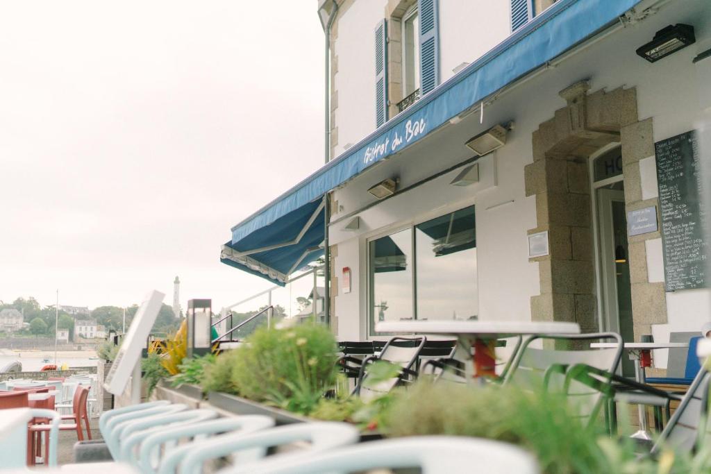 a group of chairs and tables outside of a building at Hotel Du Bac in Combrit